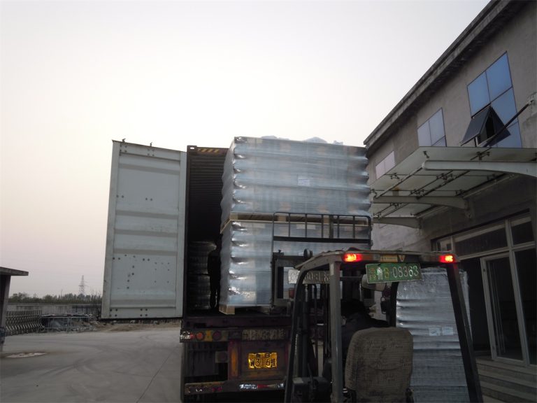 Workers putting the stacked wheel stops into the container to be shipped to other countries