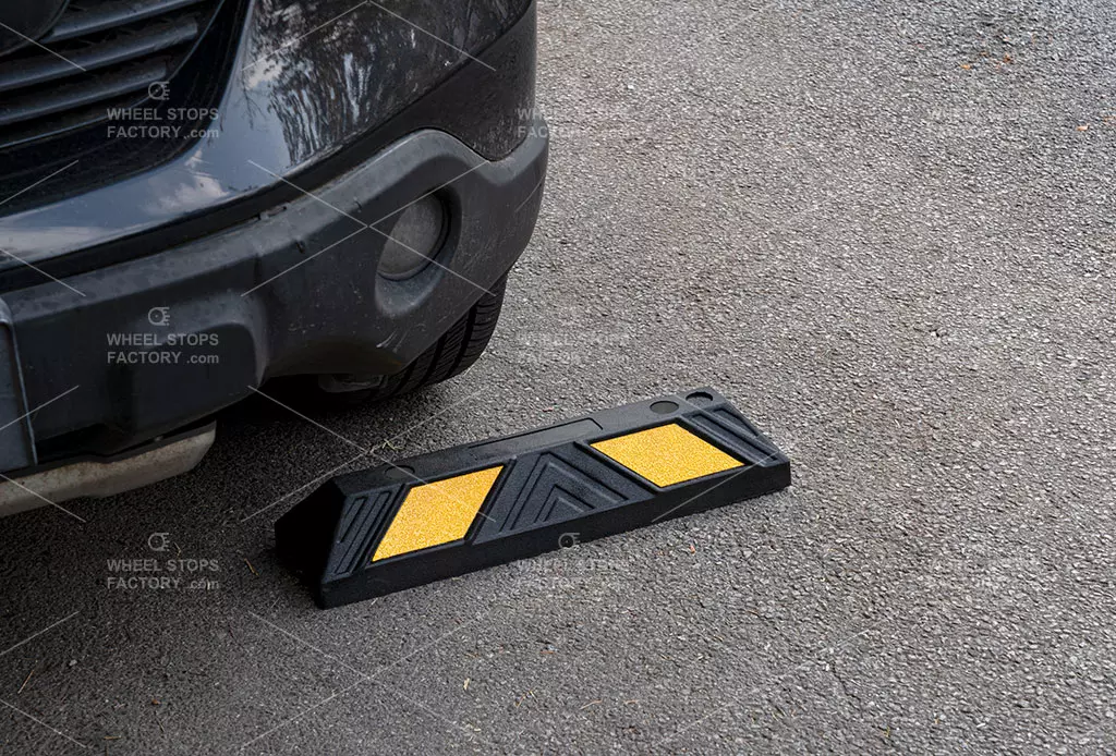 A 550 mm garage wheel stop installed on an asphalt surface