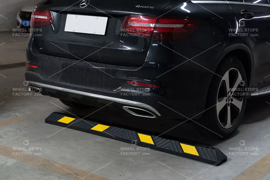 A black and yellow parking kerb stop is installed in the garage for safe parking purposes