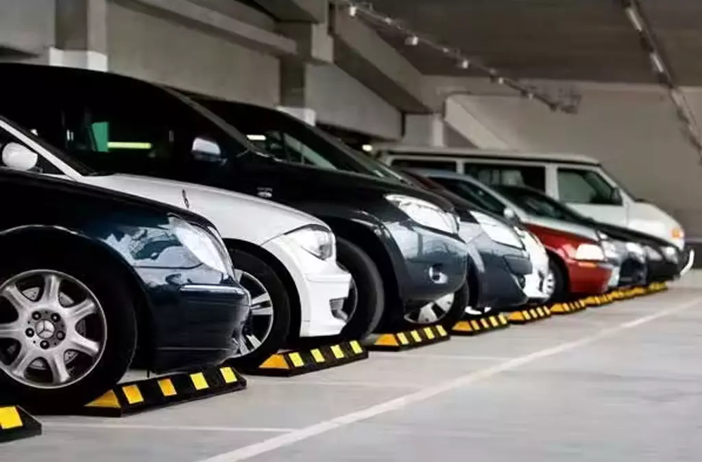 A group of black and yellow Park-it wheel stops installed in the parking lot