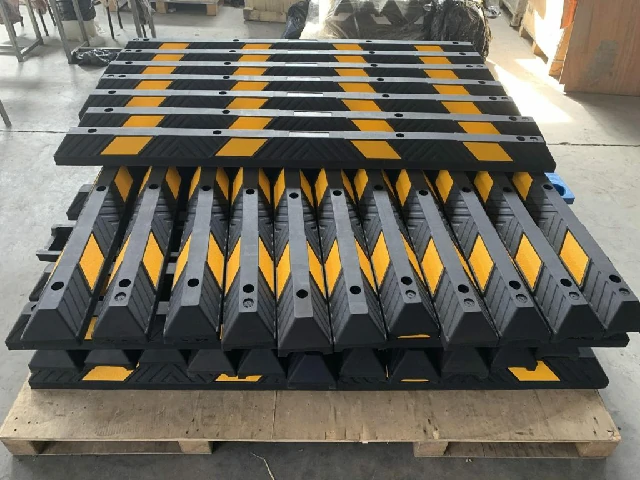 Stacks of black and yellow parking stops made from rubber and plastic mix