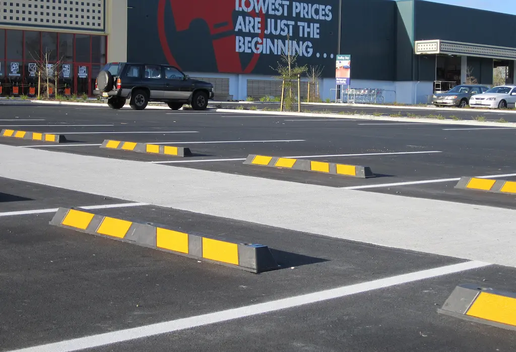 Black and yellow parking lot bumpers used to manage parking.