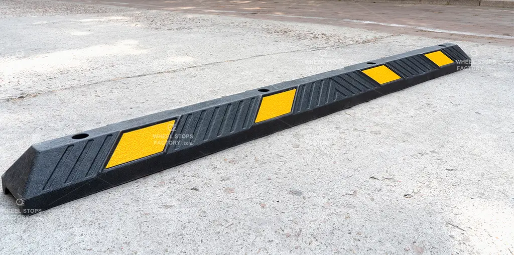 A black Plastic-Rubber composite parking stop with yellow reflective films.